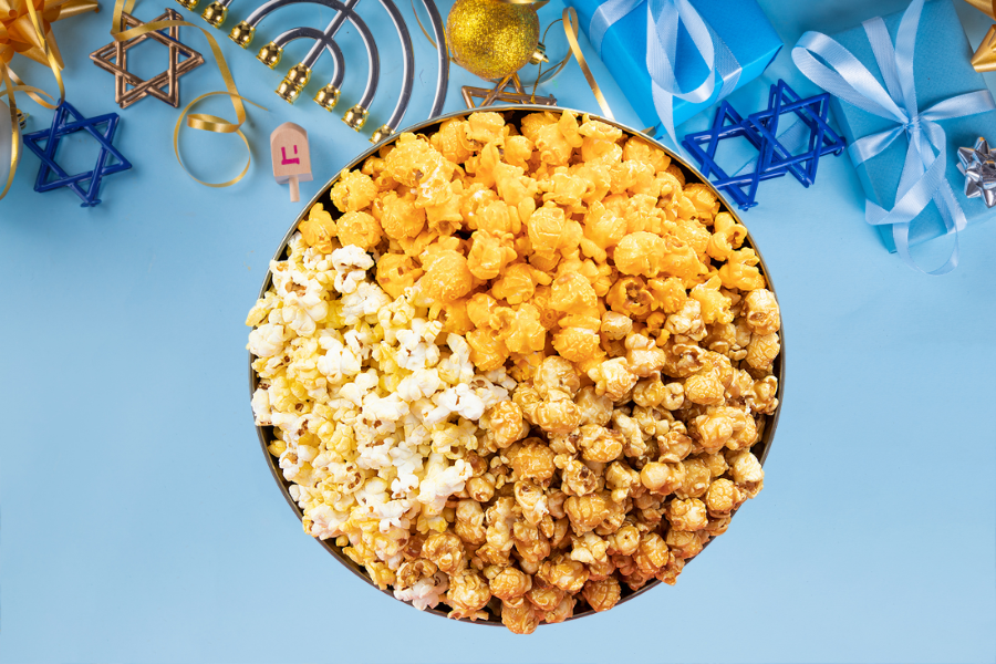 Overhead view of a popcorn tin with a hanukkah themed background